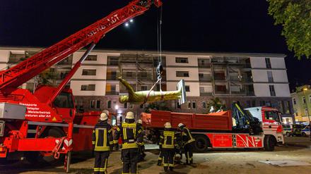 Feuerwehrleute heben eine Statue des türkischen Staatspräsidenten Erdogan auf einen Lkw. 