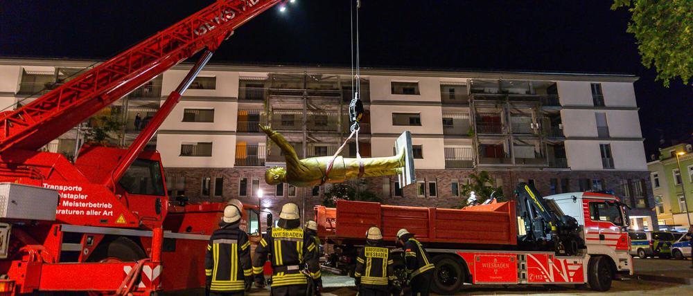 Feuerwehrleute heben eine Statue des türkischen Staatspräsidenten Erdogan auf einen Lkw.