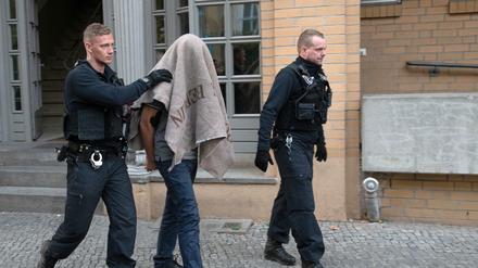 Polizisten führen einen verdächtigen Mann in der Pohlstraße ab.