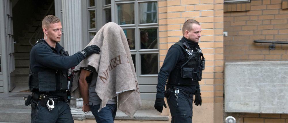 Polizisten führen einen verdächtigen Mann in der Pohlstraße ab.