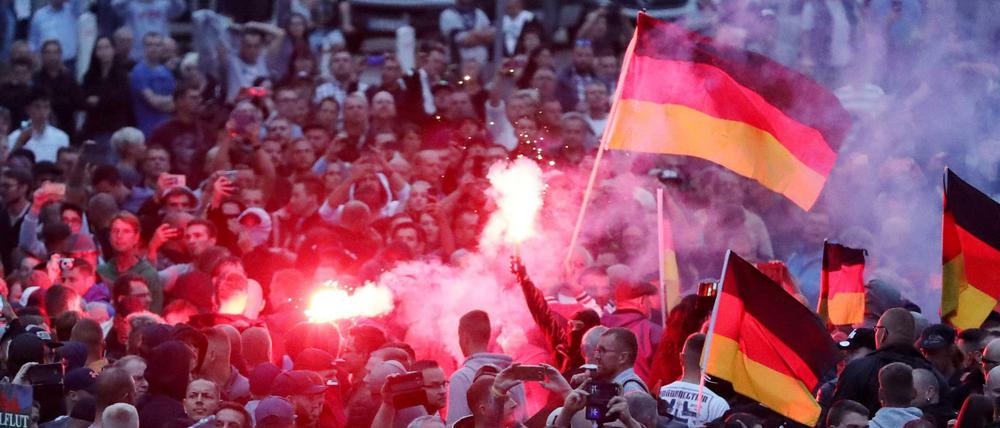 Demonstranten der rechten Szene zünden in Chemnitz Pyrotechnik und schwenken Deutschlandfahnen.