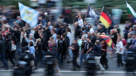 Anhänger der rechten Szene schwenken am Montagabend in Chemnitz Deutschlandfahnen.