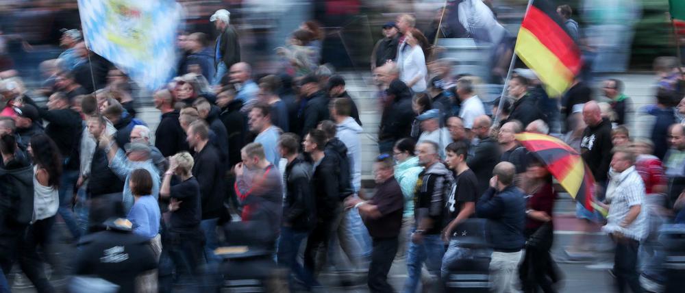 Anhänger der rechten Szene schwenken am Montagabend in Chemnitz Deutschlandfahnen.