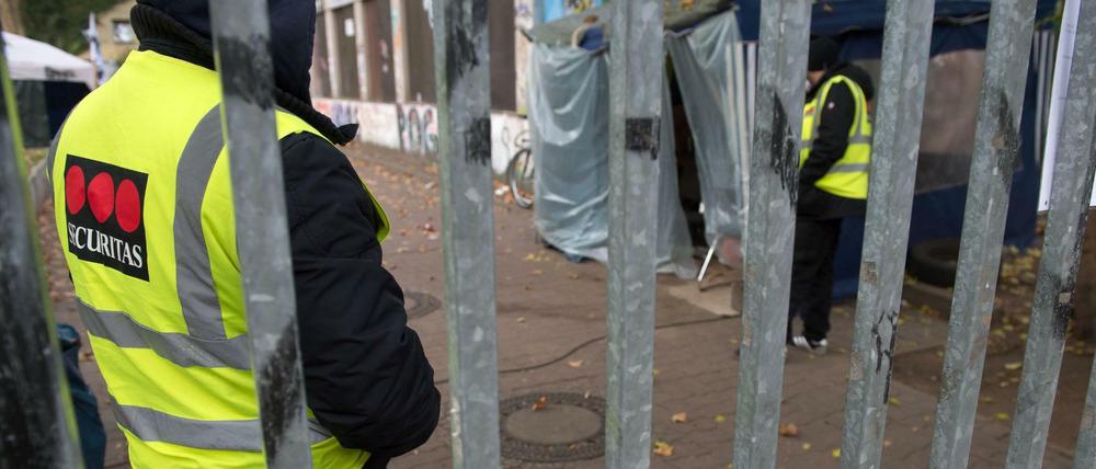 Wachleute eines Sicherheitsdienstes stehen 2014 hinter dem Tor der besetzten Gerhart-Hauptmann-Schule in Kreuzberg.