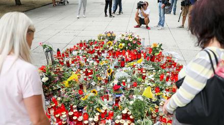 Passanten stehen am Tatort in Chemnitz.