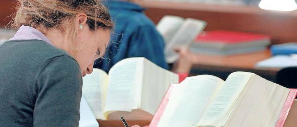 Eine Jurastudentin lernt in der Bibliothek.