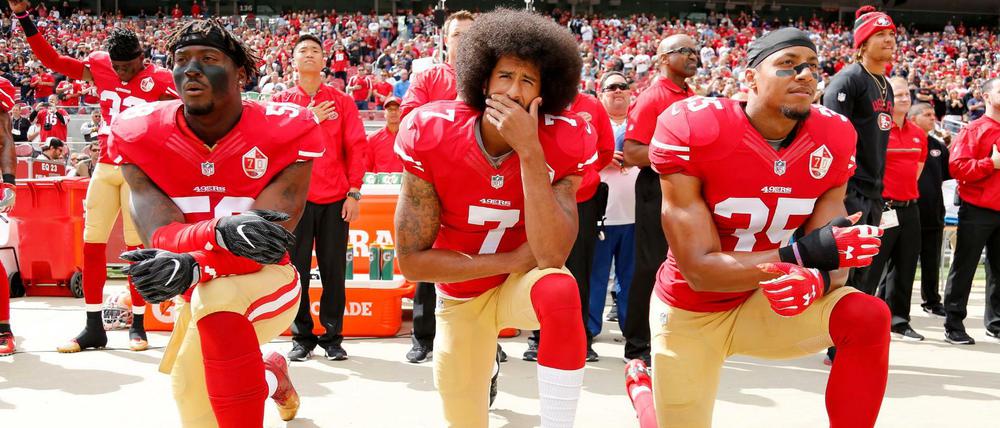 Auf die Knie. Der Quarterback Colin Kaepernick (M.), 2016 noch für die San Francisco 49ers aktiv, protestiert mit Eli Harold (l.) und Eric Reid (r.) während die Nationalhymne läuft.