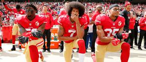 Auf die Knie. Der Quarterback Colin Kaepernick (M.), 2016 noch für die San Francisco 49ers aktiv, protestiert mit Eli Harold (l.) und Eric Reid (r.) während die Nationalhymne läuft.