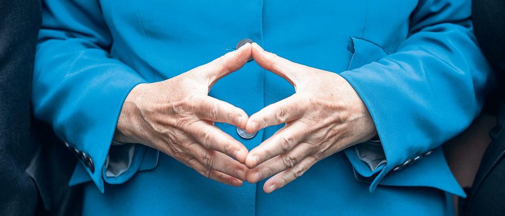 Bundeskanzlerin Angela Merkel (CDU) hat ihre Hände zur Raute geformt.