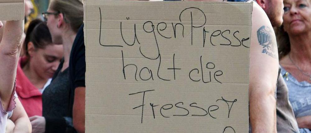 Ein Teilnehmer einer Kundgebung rechter Gruppen in Köln hält ein Plakat mit der Aufschrift "Lügenpresse halt die Fresse".
