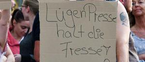 Ein Teilnehmer einer Kundgebung rechter Gruppen in Köln hält ein Plakat mit der Aufschrift "Lügenpresse halt die Fresse". 