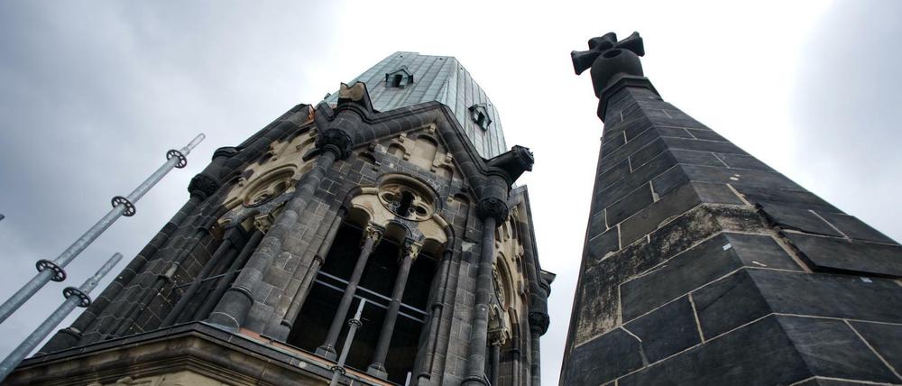 Turm der Kaiser-Wilhelm-Gedächtniskirche in Berlin ragt auf in dunkle Wolken.