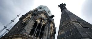  Turm der Kaiser-Wilhelm-Gedächtniskirche in Berlin ragt auf in dunkle Wolken.