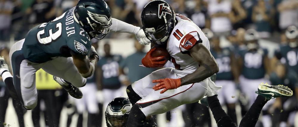 Rustikaler Beginn. Atlantas Julio Jones (M, 11) wird von Philadelphias Ronald Darby (unten) und Rodney McLeod (l, 23) in die Zange genommen. 