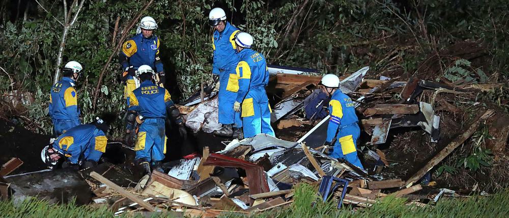 Rettungskräfte suchen in Trümmern nach Opfern.
