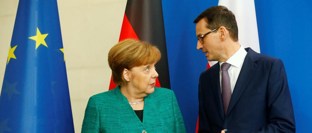 Chancellor Angela Merkel and Polish Prime Minister Mateusz Morawiecki address a news conference in Berlin, Germany, February 16, 2018. REUTERS/Hannibal Hanschke