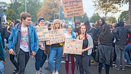 Eine Gruppe junger Menschen hält bei einer Demonstration in Chemnitz Plakate mit Aufschriften wie "Wir sind alle Menschen" und "Menschenrechte statt rechte Menschen" hoch.