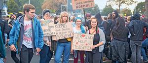 Eine Gruppe junger Menschen hält bei einer Demonstration in Chemnitz Plakate mit Aufschriften wie "Wir sind alle Menschen" und "Menschenrechte statt rechte Menschen" hoch.