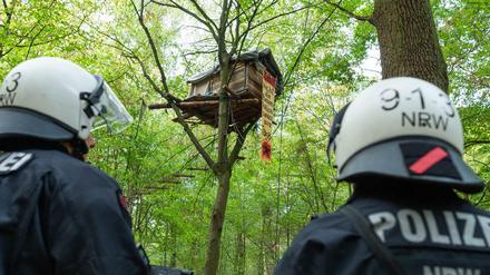 Zwei Polizisten stehen vor einem Baumhaus von Aktivisten im Hambacher Forst (Archivbild von 2018).