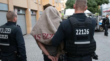 Polizisten führen einen verdächtigen Mann nach einer Razzia gegen kriminelle Mitglieder arabischer Großfamilien Ende August ab.