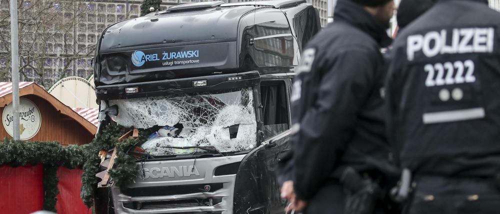 Polizisten stehen vor dem zerstörten Lkw am Weihnachtsmarkt am Breitscheidplatz in Berlin.