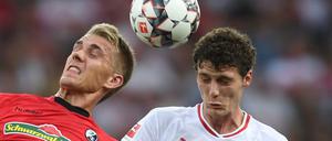 Nils Petersen (l) von Freiburg kämpft mit Benjamin Pavard (r) von Stuttgart um den Ball. 