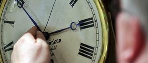Ein Uhrenhändler stellt eine Uhr von zwei auf drei Uhr vor. 