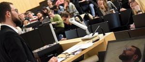 Ein Professor steht vor Studierenden im Hörsaal.