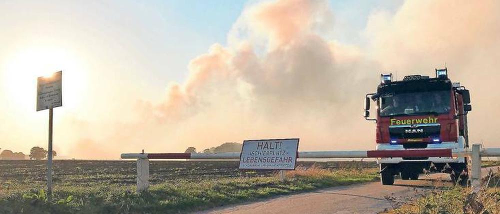 Ein Löschfahrzeug der Feuerwehr steht an einer Schranke zum Gelände.
