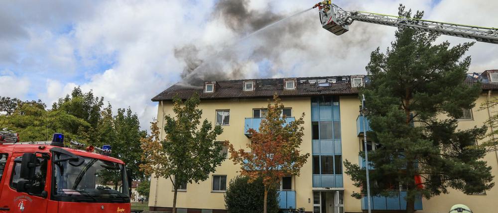 Die Feuerwehr löscht den Dachstuhlbrand in einem Ankerzentrum für Flüchtlinge. Ein Gebäude der Wohneinrichtung musste nach Angaben der Polizei Oberfranken geräumt werden.