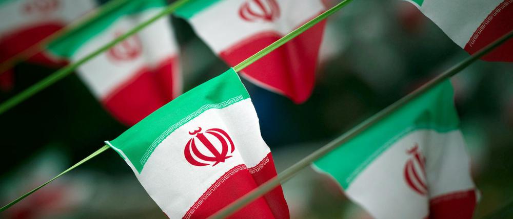 Iranische Flaggen wehen auf einer Straße in Teheran.