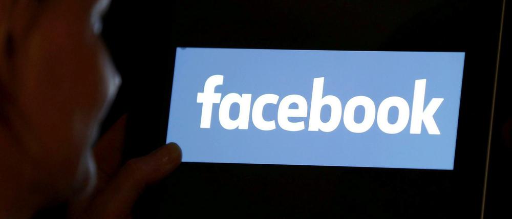 Eine Frau schaut auf einen Bildschirm mit dem Facebook-Logo. (Symbolbild)