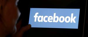 Eine Frau schaut auf einen Bildschirm mit dem Facebook-Logo. (Symbolbild)