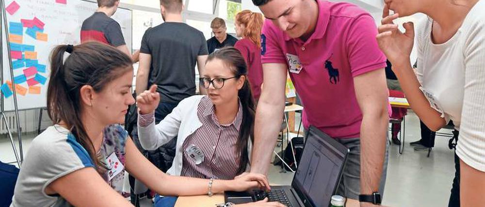 Studierende diskutieren bei einem Hackathon in Berlin.