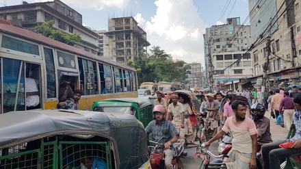 Autos, Busse, Mopeds, Motorräder, Fahrräder, Rikschas und Handkarren teilen sich in Dhaka die Straße.