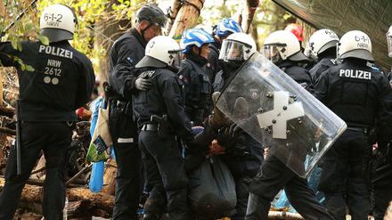 Im Hambacher Forst tragen Polizisten einen Demonstranten weg.