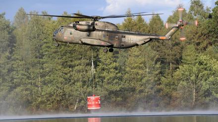Ein Transporthubschrauber der Bundeswehr nimmt in Meppen Wasser zur Bekämpfung eines großflächigen Moorbrands auf.