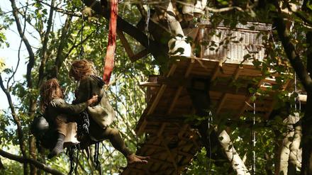Im Hambacher Forst seilen sich zwei Aktivisten aus einem Baumhaus ab.
