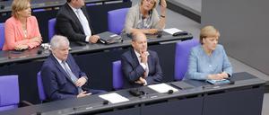 Horst Seehofer (CSU), Olaf Scholz (SPD) und Angela Merkel (CDU) sitzen nebeneinander im Bundestag.