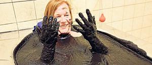 Der Kopf bleibt draußen. Unsere Autorin taucht ein in 220 Liter Moor, die Pampe soll bei vielen Krankheiten lindernd wirken.