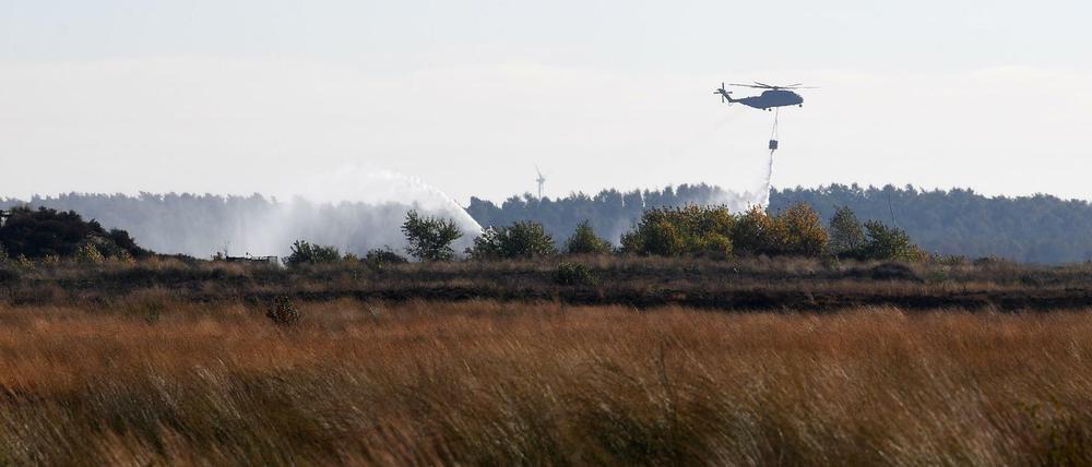 Ein Transporthubschrauber CH-53 der Bundeswehr gibt beim Moorbrand in Meppen Wasser ab.