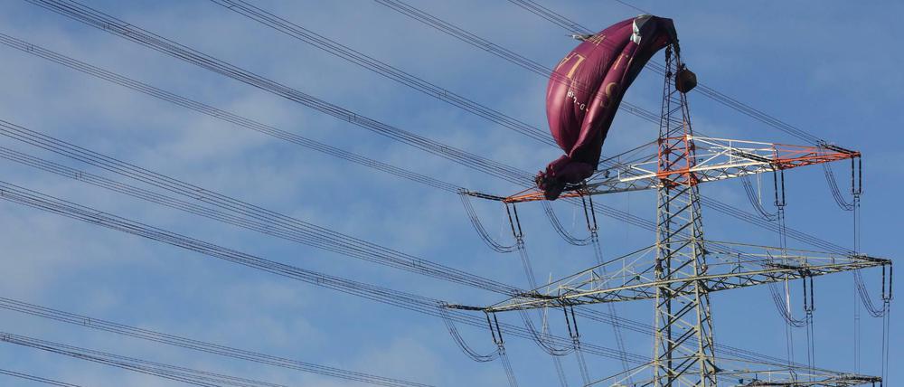 Der an einer Hochspannungsleitung verunglückte Heißluftballon wird von einem Höhenretter untersucht.