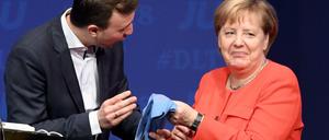 Zum Abschied schenkt der Vorsitzende der Jungen Union (JU), Paul Ziemiak, Merkel ein Paar Socken.
