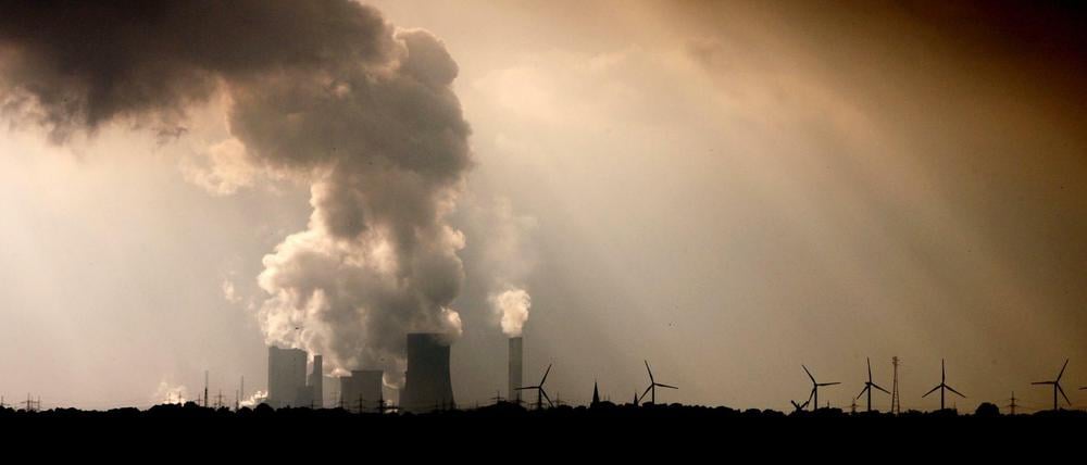 Dampf steigt aus den Kühltürmen und Schornsteinen des RWE-Braunkohlekraftwerks Niederaußem bei Bergheim.