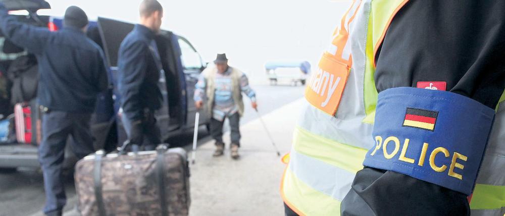 Polizisten begleiten abgelehnte Asylbewerber aus Tunesien auf dem Flughafen Leipzig-Halle.