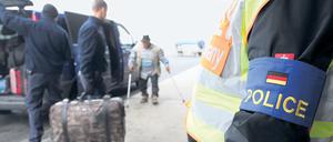 Polizisten begleiten abgelehnte Asylbewerber aus Tunesien auf dem Flughafen Leipzig-Halle.