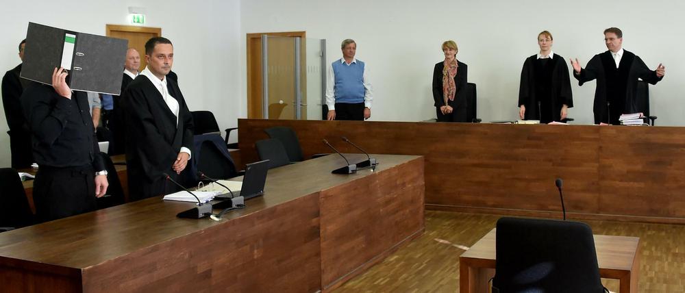 Einer der Angeklagten (l) hatte Revision gegen die Höhe der Gesamtstrafe eingelegt und hält sich zu Verhandlungsbeginn einen Aktenordner vor das Gesicht.