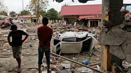 Männer betrachten die Schäden in einem vom Tsunami verwüsteten Gebiet in Palu. Ein Erdbeben hatte die Provinz Zentral-Sulawesi am 28. September 2018 erschüttert und einen Tsunami ausgelöst.