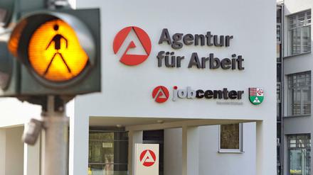 Eine Ampel warnt Autofahrer vor kreuzenden Fußgänger auf dem Weg zur Agentur für Arbeit.