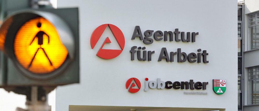 Eine Ampel warnt Autofahrer vor kreuzenden Fußgänger auf dem Weg zur Agentur für Arbeit.